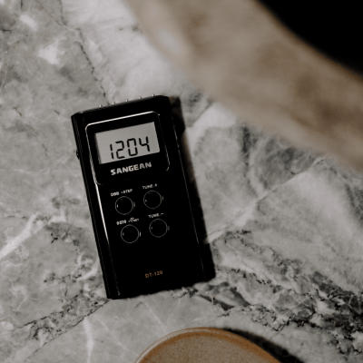 Leitor de rádio digital preto com ecrã LCD sobre mármore cinzento