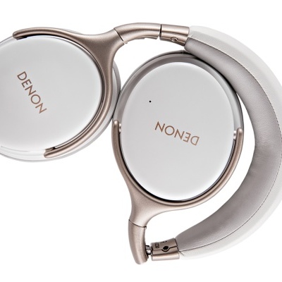 Auscultadores Denon branco e dourado dobrados sobre fundo branco