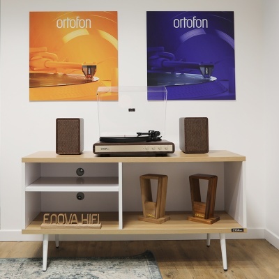 aparelho de som vintage com gira-discos e colunas num móvel com imagens 'ortofon' ao fundo