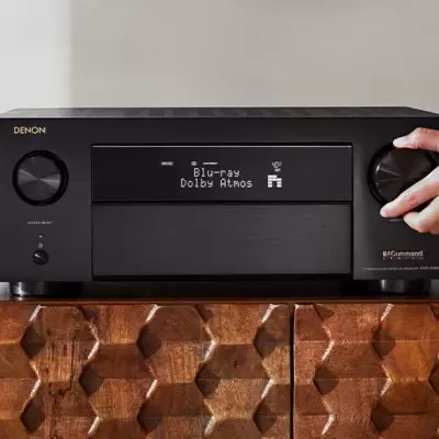 Amplificador preto Denon com display digital sobre móvel de madeira padronizado