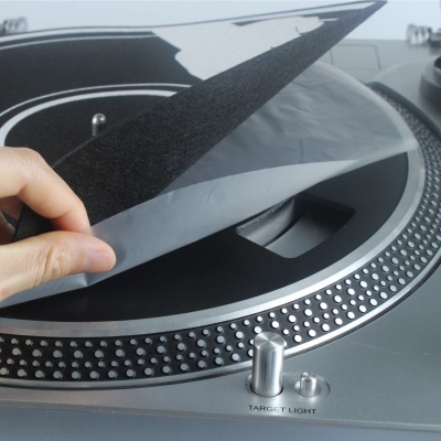 Toca-discos cinzento com disco de vinil preto e capa protetora transparente