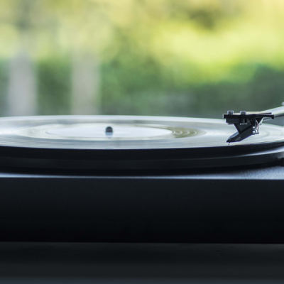 Toca-discos preto com prato de vinil transparente e braço de leitura