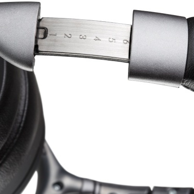 Detalhe do ajuste numerado de fones de ouvido pretos com acabamento em metal prateado