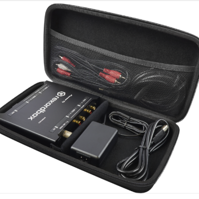 Estojo preto aberto com aparelho Chordbox, adaptador e cabos organizados dentro.