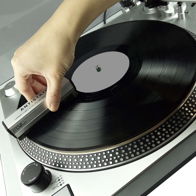 Gira-discos com disco vinil preto e mão segurando agulha Antistatic ED04