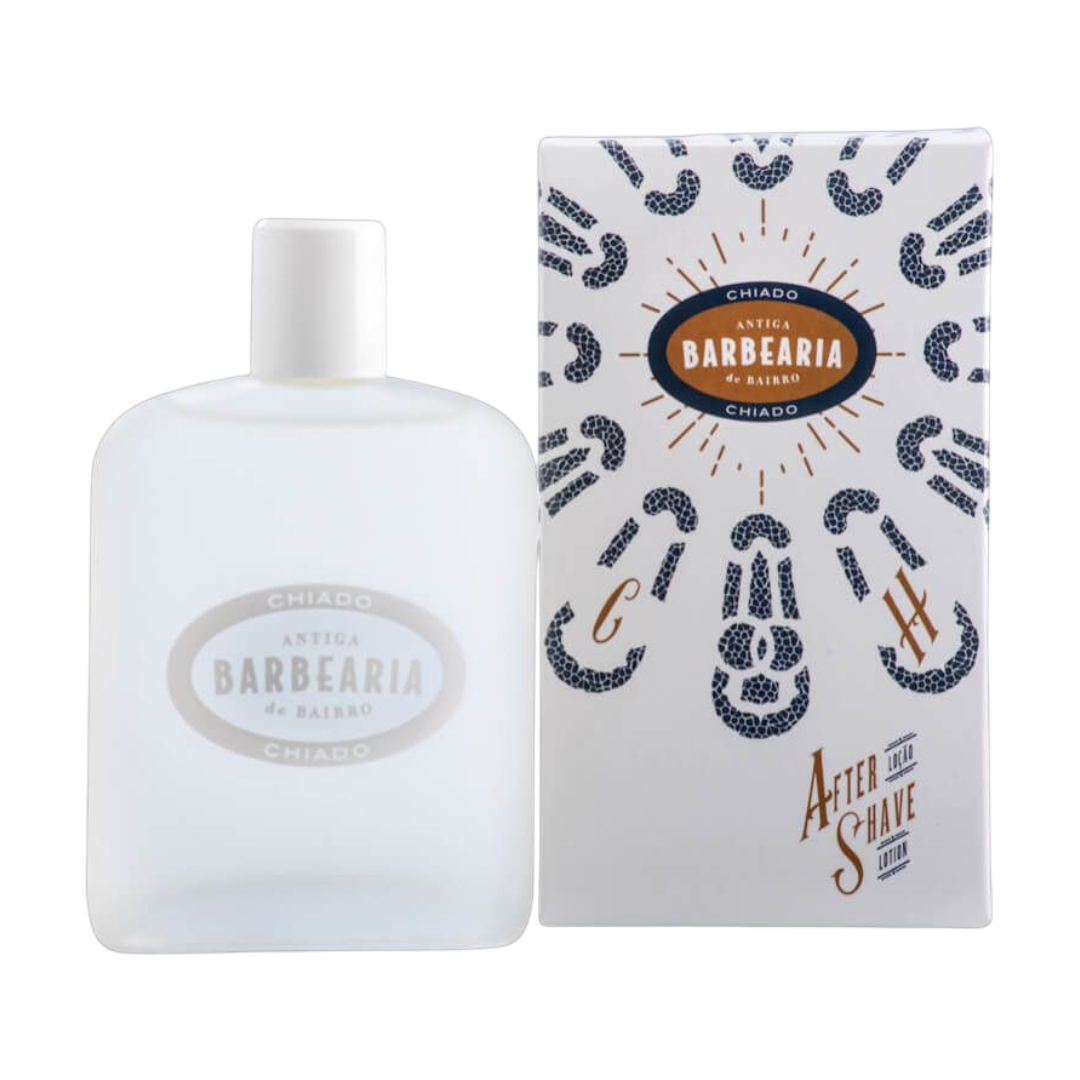 Antiga Barbearia de Bairro - After Shave Chiado Frasco fosco branco de after shave ao lado de embalagem com padrão azul e dourado