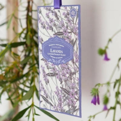 Saco perfumado Castelbel Lavanda com design floral lilás e verde, texto em azul e branco, pendurado com fita roxa