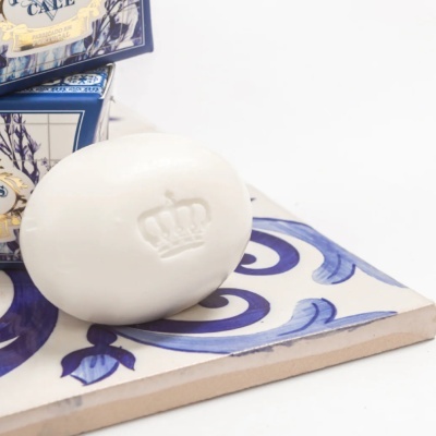 Sabonete branco com coroa em relevo sobre azulejo azul e branco