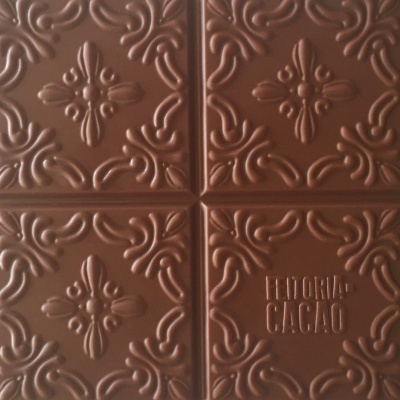 Barra de chocolate castanha com textura floral e texto FEITORIA CACAO