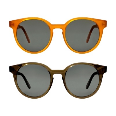 Dois pares de óculos de sol redondos laranja e verde escuro com lentes cinzentas.