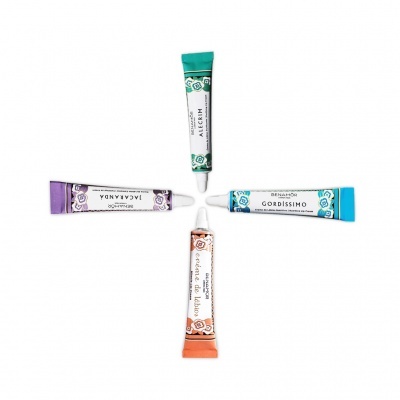 quatro tubos pequenos de creme coloridos com tampas brancas