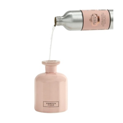 Frasco rosa a ser preenchido com líquido de frasco metálico