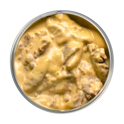 Lata aberta com comida húmida cremosa para animais, pedaços marrons em molho amarelo claro
