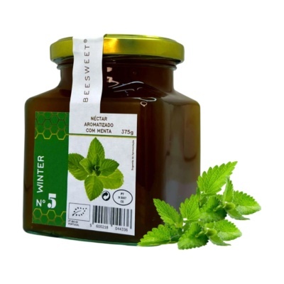 Frasco de néctar aromatizado com menta com rótulo verde e branco e folhas de menta ao lado