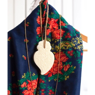 Lenço azul com padrão floral e pendente decorativo branco