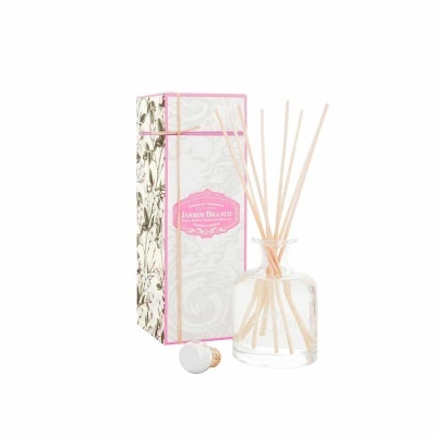 Frasco de aromatizador com palitos ao lado da caixa decorativa floral e etiqueta rosa