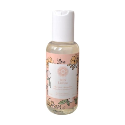 Garrafa de gel para banho e champô com etiqueta floral cor de rosa.