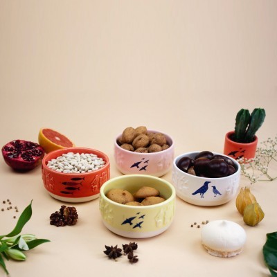 tigelas de cerâmica coloridas com frutos secos sobre superfície bege