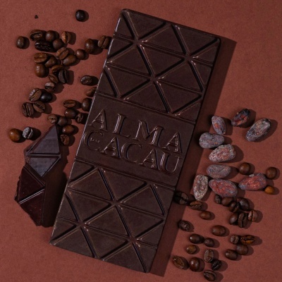 Barra de chocolate castanho escuro com grãos de café e bagas de cacau secas