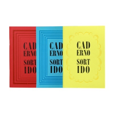 Três cadernos coloridos com texto CAD ERNO SORT IDO nas capas.