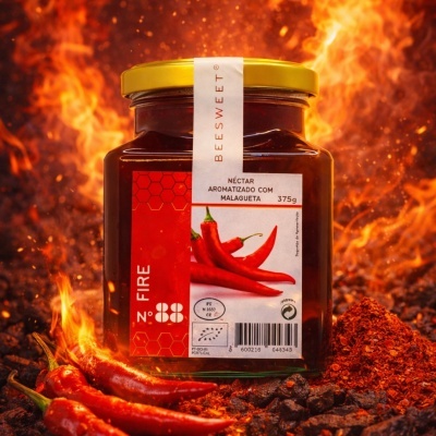 Frasco de néctar com malagueta em cenário de fogo e pimentos.