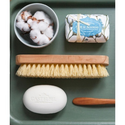Conjunto de produtos de limpeza e cuidados pessoais sobre superfície verde