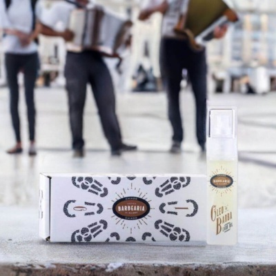 Spray de óleo de barba com caixa branca decorada e pessoas ao fundo