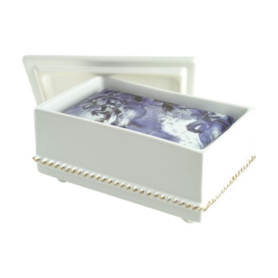 Caixa cerâmica branca com almofada azul decorativa