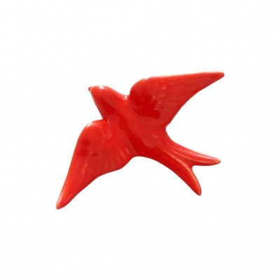 Peça decorativa vermelha em forma de pássaro com asas abertas