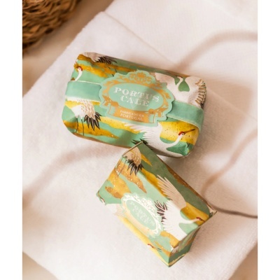Sabonetes embalados em papel com padrão de aves brancas e texto PORTUS CALE.