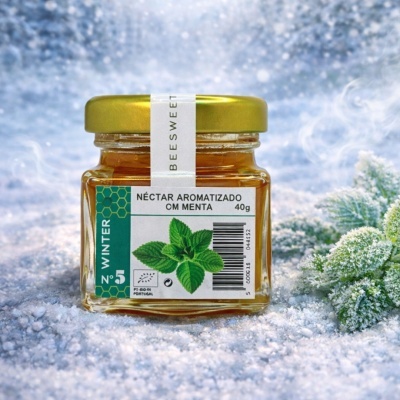 Frasco de néctar aromatizado de menta numa superfície congelada com folhas verdes cobertas de geada