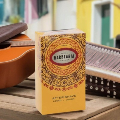 Embalagem amarela decorada de after shave ao lado de guitarra e instrumento musical