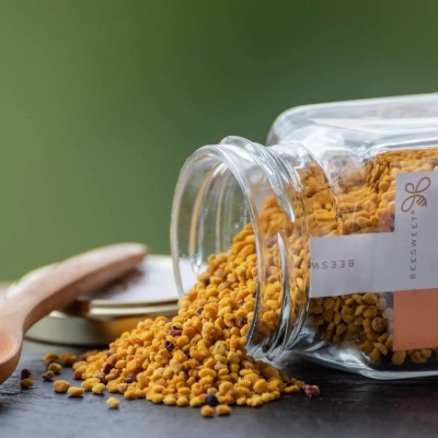 Frasco de vidro com grânulos amarelos e etiqueta Beesweet