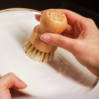 Escova de madeira com cerdas brancas para limpeza em superfície branca com espuma