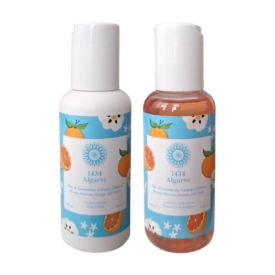 Frascos pequenos com loção corporal e gel de duche, rótulos azuis com laranjas e flores.