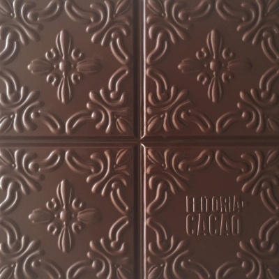 Barra de chocolate com padrão floral em relevo e texto LUDORIA CACAO