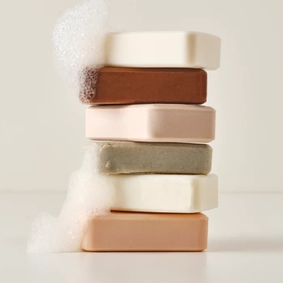 Cinco sabonetes em barra empilhados com espuma