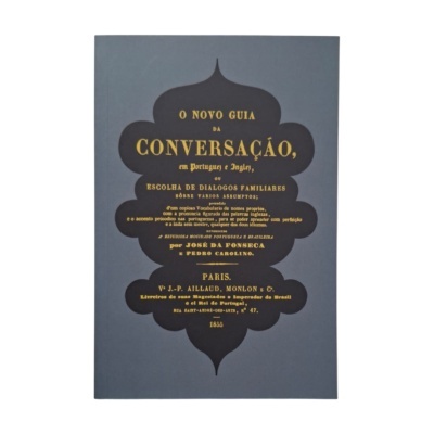 Livro antigo de capa azul com texto amarelo sobre guia de conversação em português e inglês.