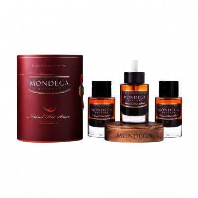 Conjunto de molhos picantes em frascos de vidro âmbar com embalagem vermelha e suporte de madeira.