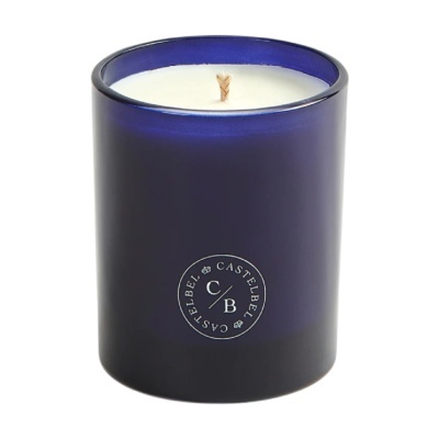 Vela branca em recipiente de vidro azul com texto CASTELBEL