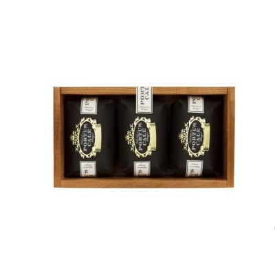 Caixa de madeira com três pacotes pretos de café Forty Grams Coffee.