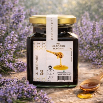 Frasco de mel multifloral biológico com colher de madeira e flores lavanda