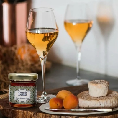 Taças de vinho, creme de amora, frutas e queijos sobre mesa de madeira