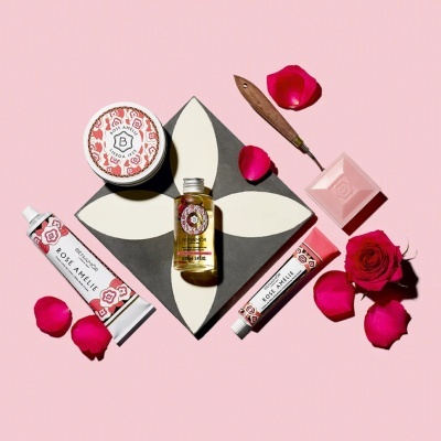 Produtos cosméticos Benamôr Rose Amélie com flores de rosa sobre fundo rosa