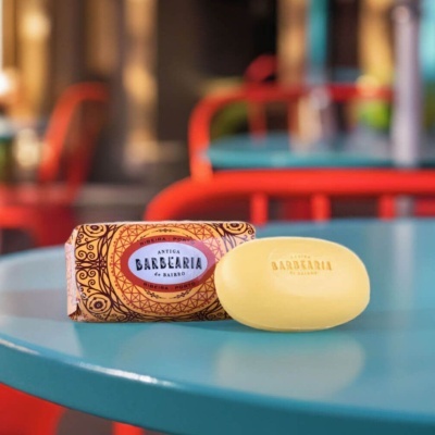 Sabonete amarelo com embalagem decorativa em papel sobre mesa azul