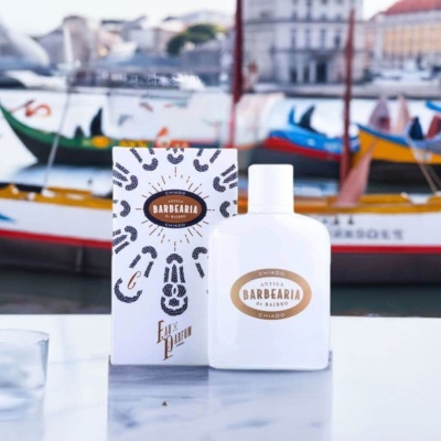 Frasco branco e caixa para perfume Antiga Barbearia de Bairro em fundo com barcos