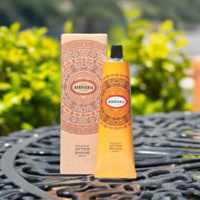 bálsamo after shave em tubo laranja e caixa bege com padrão em mesa metálica preta ao ar livre