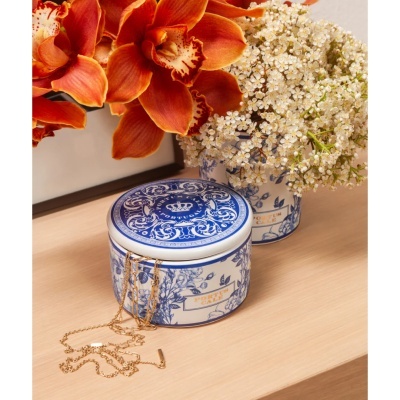 Duas caixas cerâmicas azuis e brancas com texto PORTUGALE e corrente dourada sobre superfície de madeira com flores