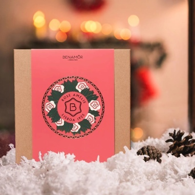 Embalagem BENAMÔR Rose Amélie com rótulo rosa e ilustração floral sobre neve artificial e pinhas