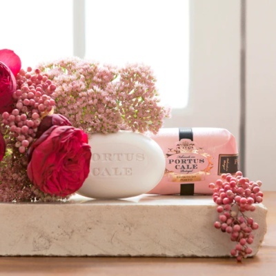 Sabonete branco e embalagem rosa da marca Portus Cale com flores cor-de-rosa e vermelhas